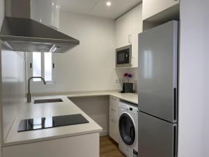 una cucina con frigorifero, lavatrice e asciugatrice di Apartamento Kemacu a Barcellona