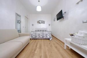Sala de estar blanca con cama y sofá en B&B Giuly, en Fiumicino