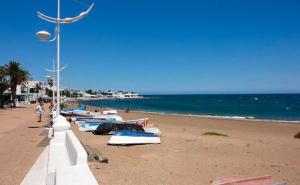 a beach with boats on the sand and the ocean at Sunrise IN LOFT in Playa Honda
