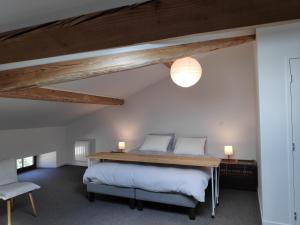 a bedroom with a bed and a table and a chair at LAne Têtu in Désaignes