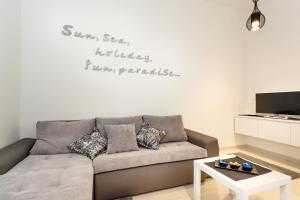 a living room with a couch with a quote on the wall at Villa Palma Krk in Krk