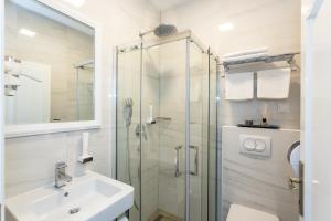 a bathroom with a glass shower and a sink at Villa Palma Krk in Krk