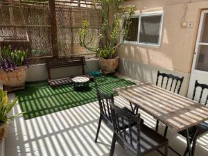 a patio with a wooden table and chairs on a porch at Loren Village in Neve Zohar