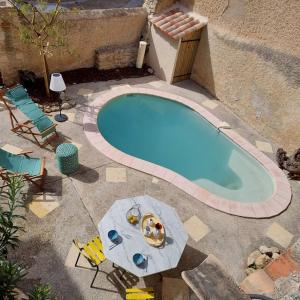 einen kleinen Pool mit Stühlen und einem Tisch in der Unterkunft Mon Ventoux in Modène