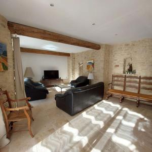 ein Wohnzimmer mit einem schwarzen Ledersofa und Stühlen in der Unterkunft Mon Ventoux in Modène + 17 Fotos