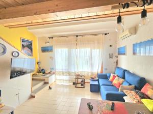 sala de estar con sofá azul y TV en Villa Bellavista IS MOLAS PULA, CAGLIARI en Santa Margherita di Pula