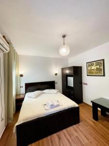 um quarto com uma cama grande e uma mesa em Hotel Nature em Kolonjë