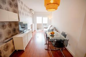 cocina con mesa de cristal y TV en For Your Rentals Coqueto apartamento cerca al Parque Retiro GPA92 en Madrid