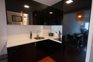 cocina con fregadero y microondas en For Your Rentals Coqueto apartamento cerca al Parque Retiro GPA92 en Madrid