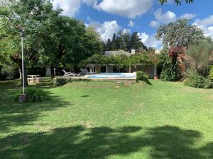 a large yard with a swimming pool in the grass at La Quinta de Pablo in Mercedes