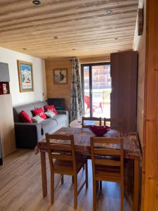 a living room with a table and chairs and a couch at Appartement "Le Sporting" à 5 min des pistes in La Salle Les Alpes