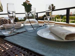 una mesa con un plato y vasos sobre una mesa en "La Cala de Mijas Bright Apartment with Sea Views Near the Beach", en La Cala de Mijas