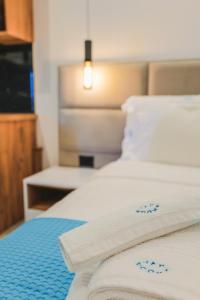 2 bedden in een hotelkamer met witte lakens bij JAD rooms in Sarandë
