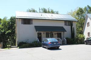 a car parked in a parking lot in front of a house at A Slice of High Country Heaven, Seven Devils Condo in Seven Devils