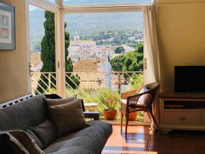 un soggiorno con divano e una grande finestra di Casa Adela /Terraza/5m playa / Aire acondicionado a Cadaqués