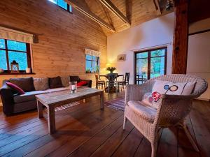 a living room with a couch and a table at Sosnowy Zakatek in Zyzdrojowy Piecek