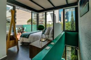 um quarto com uma cama num quarto com janelas grandes em Mr. W GREAT MODERN-SUNNY PH LUXE oxford 23 mar em Cidade do México