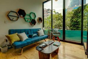 uma sala de estar com um sofá azul e uma mesa em Mr. W GREAT MODERN-SUNNY PH LUXE oxford 23 mar em Cidade do México