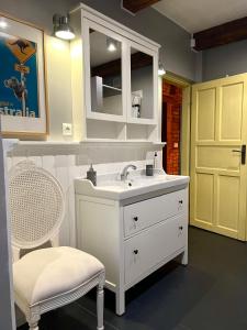 ein weißes Badezimmer mit einem Waschbecken und einem Stuhl in der Unterkunft Sosnowy Zakatek in Zyzdrojowy Piecek