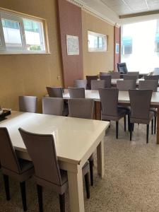 uma sala de espera com mesas, cadeiras e janelas em SİES OTEL em Antalya