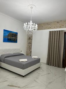 a bedroom with a bed and a chandelier at B&B bella vista in Pizzo
