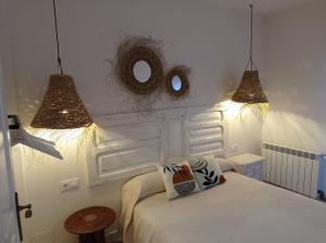 1 dormitorio con 2 luces, 1 cama y espejo en Apartamentos La Muralla, en Santo Domingo de la Calzada