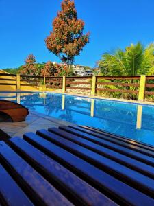 un banco sentado junto a una valla junto a una piscina en Meu Cantinho Familiar, en Búzios