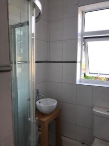 a bathroom with a sink and a glass shower at Hilltop Cottage in Renishaw