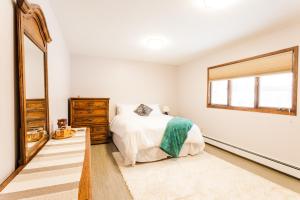 - une chambre avec un lit, une commode et un miroir dans l'établissement Relaxing Lake Haven House - Close to EVERYTHING!, à Anchorage