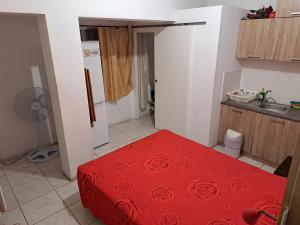 małą kuchnię z czerwonym łóżkiem w pokoju w obiekcie City Large Studio w mieście Limassol