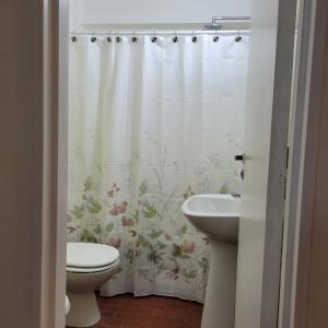 a bathroom with a shower curtain with a toilet and a sink at Palermo Botánico in Buenos Aires