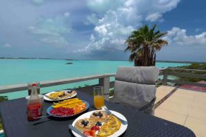 einen Tisch mit Speisen und Meerblick in der Unterkunft Turquoise Haven Villa in Providenciales