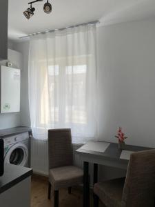 a kitchen with a table and chairs and a window at Studio Tineretului in Zalău
