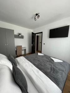 a bedroom with a large bed with a television on the wall at Studio Tineretului in Zalău
