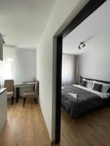 a bedroom with a large bed and a desk at Studio Tineretului in Zalău