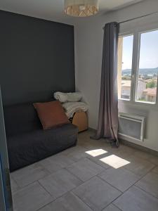 uma sala de estar com um sofá e uma janela em Villa moderne sur les hauteurs d'Aramon em Aramon