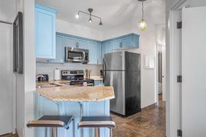 a kitchen with blue cabinets and a stainless steel refrigerator at Newly renovated Blue Sky - Family Fun - 2 Bed -2 Bath in Canmore +30 photos