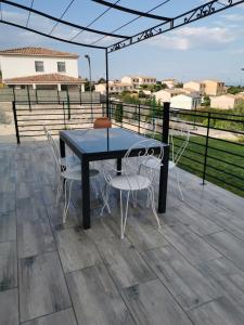 a table and chairs on a patio with a view at Villa moderne sur les hauteurs d'Aramon in Aramon