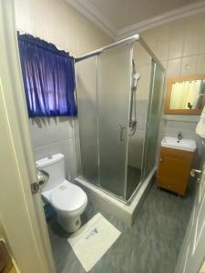 a bathroom with a toilet and a glass shower at Apartment A- 2 Bedroom Apartment) Hillside Gardens in Lagos