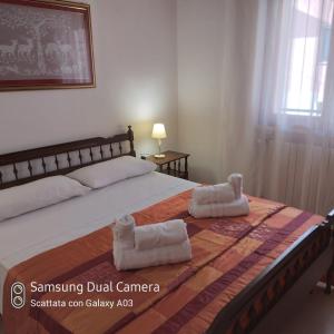 una camera da letto con un grande letto con asciugamani di Casa vacanza in Salento a Matino