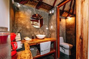 een badkamer met een wastafel, een toilet en een spiegel bij Casa Chapolin Boutique Guesthouse in Palomino