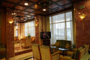 a lobby with a table and chairs and a television at Balasca Hotel in Athens