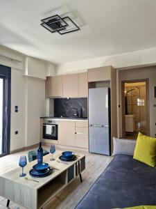 a living room with a table and a kitchen at Volos Terra Deluxe Residences in Volos