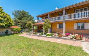 uma casa com flores no quintal da frente em Apartmani Miluška em Sveti Filip i Jakov