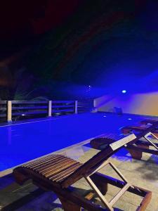 a picnic table and chairs next to a swimming pool at Meu Cantinho Familiar in Búzios