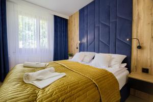 sypialnia z dużym łóżkiem z ręcznikami w obiekcie Apart Dwudziestolecie w Wadowicach
