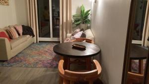 a living room with a table and chairs and a refrigerator at Depto en condo Pucon Andino in Pucón