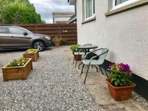 Un patio con mesa y sillas y flores. en 'Edgewood' - spacious detached bungalow, en Inverness