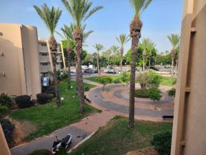 uma vista para uma rua com palmeiras e uma moto em Suite Marina Caesarea em Caesarea