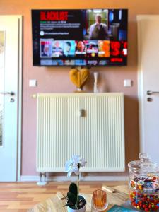 a flower in a vase on a table with a tv at Elbling Apartment mit Terrasse - Netflix - Parkplatz - Weinbergblick in Meißen